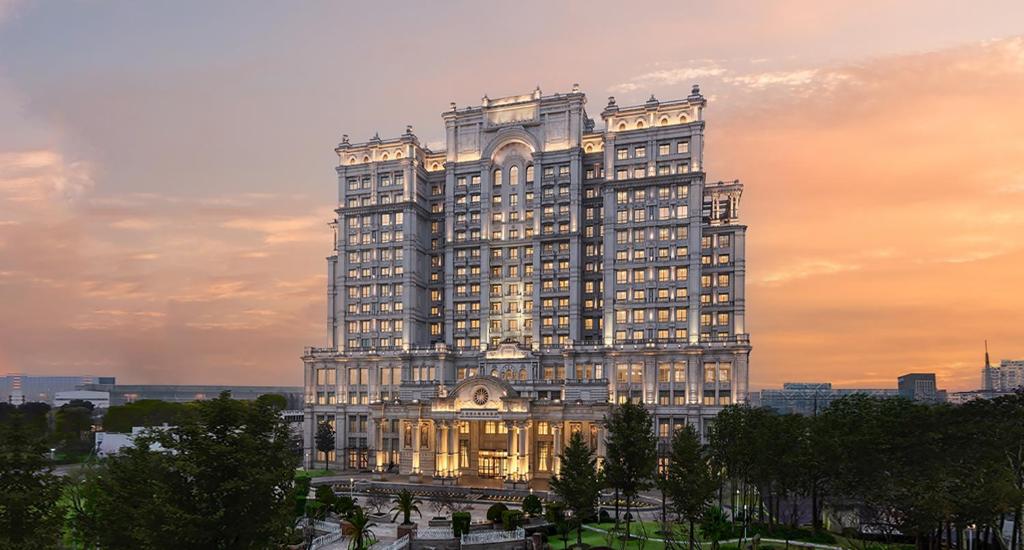 ein großes Gebäude mit Sonnenuntergang im Hintergrund in der Unterkunft Delta Hotels by Marriott Shanghai Baoshan in Baoshan