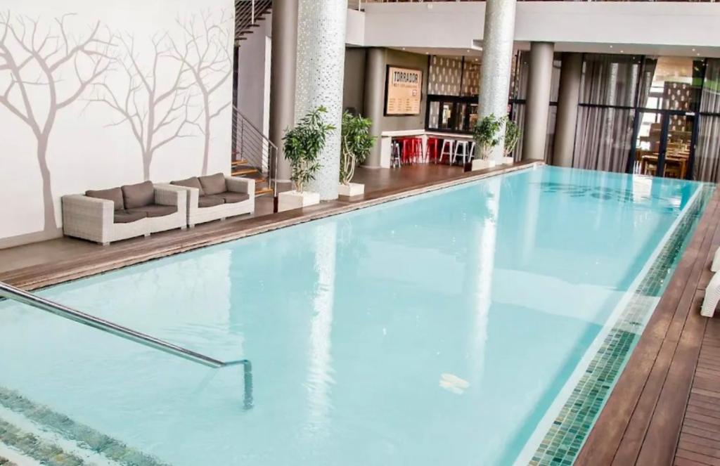 a large swimming pool in a hotel lobby at uMhlanga Condo - Location, Location, Location in Durban