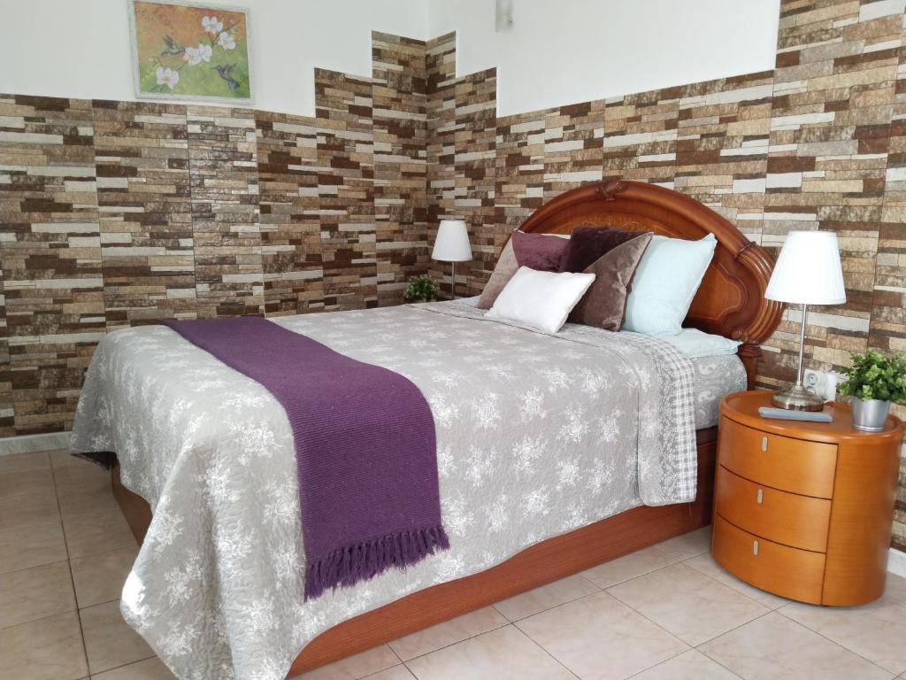 Un dormitorio con una cama grande y una pared de ladrillo. en Happy Home, en Garachico