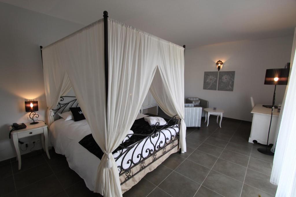 una camera con letto a baldacchino di Hôtel A Madonetta a Bonifacio