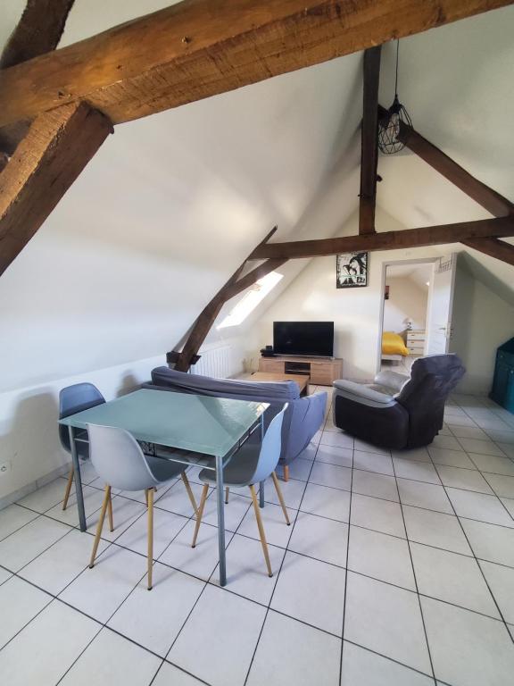 a living room with a table and chairs at Idéal famille, 2 chambres au calme in Bourgueil