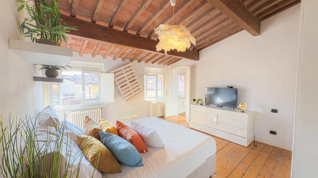 Schlafzimmer mit einem Bett mit Kissen und einem TV in der Unterkunft Sky View Residenza - Roofview free parking in Verona
