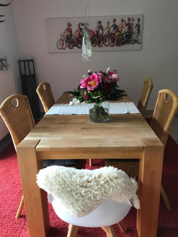 a wooden table with a vase of flowers on it at Ferienwohnung Lenzen in Kall