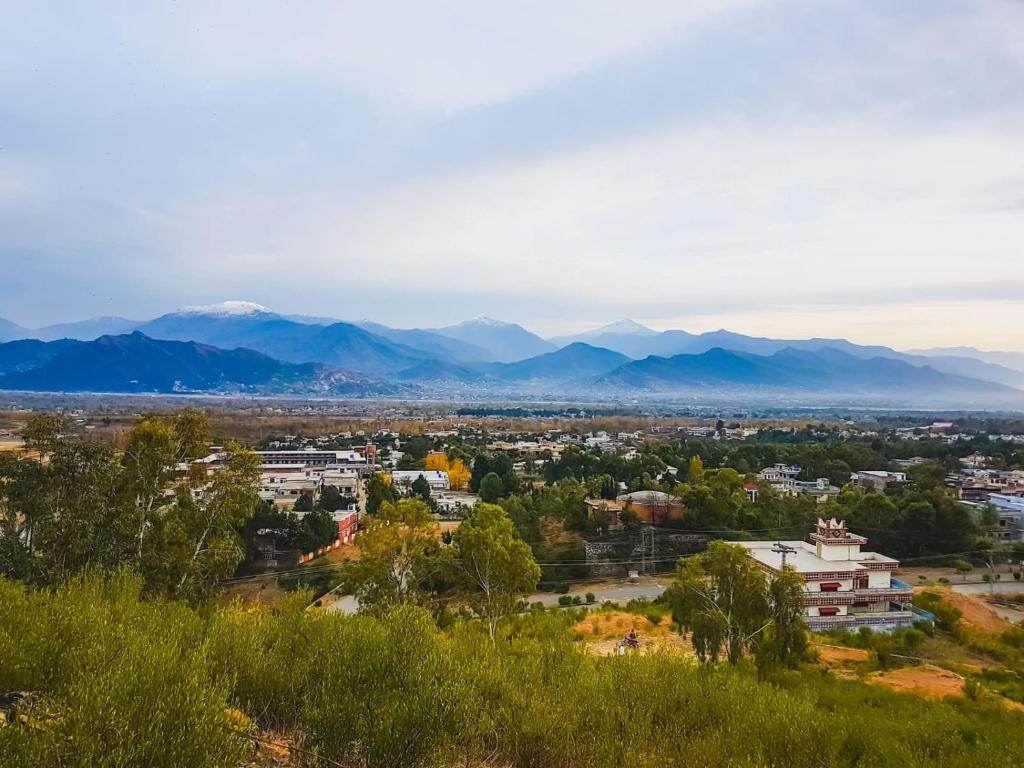 Una vista de una ciudad con montañas al fondo. en Azizullah Property, 