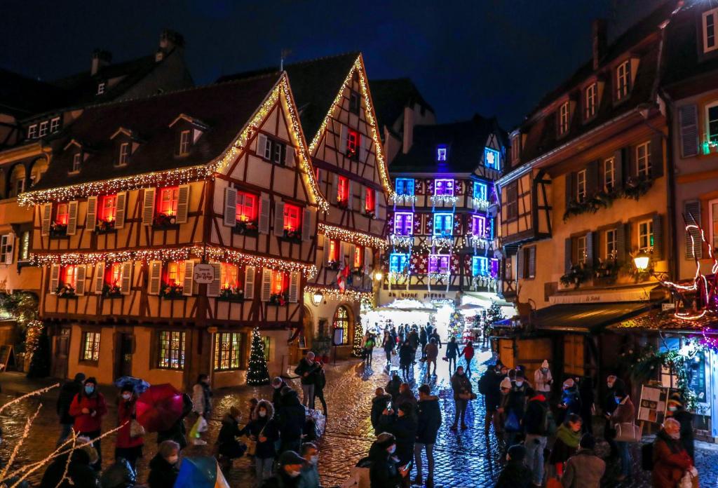 a group of people walking down a street with christmas lights at Gîte avec parking, au calme, entre Colmar-Riquewihr et Obernai ,marchés de Noël, 3 chambres, avec terrasse in Châtenois