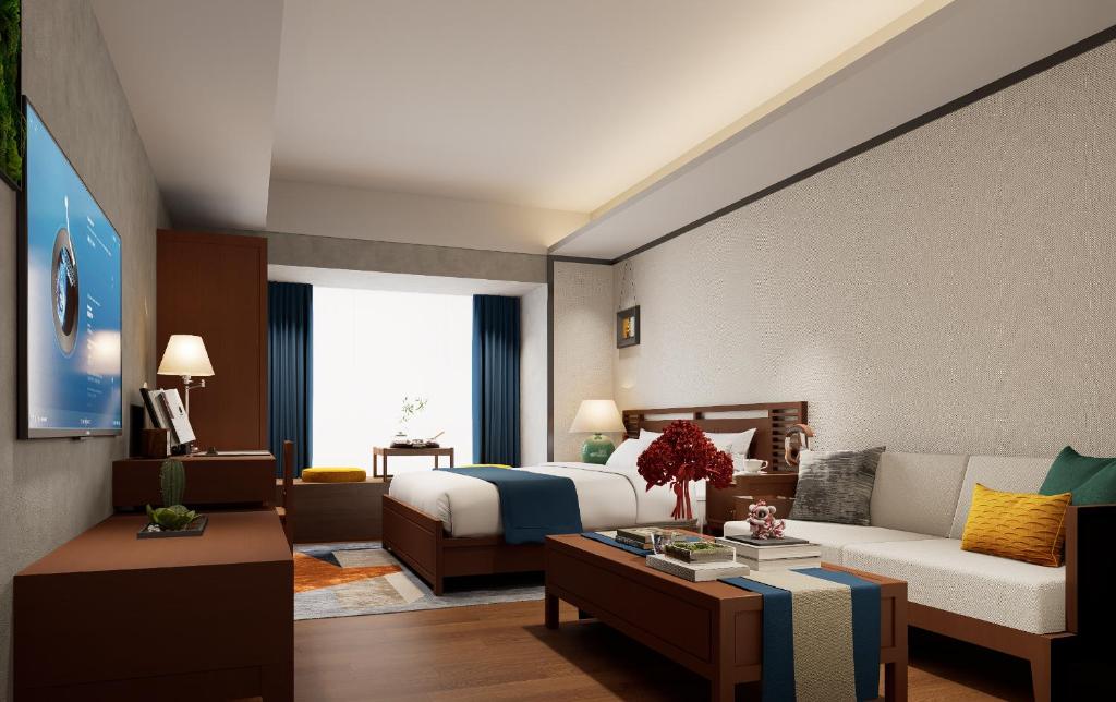 a hotel room with a bed and a living room at Guangzhou Bokeshijia Hotel in Guangzhou