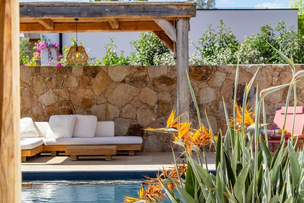 a patio with a couch next to a pool at Villa A Calia di Fiori Mare in Sainte-Lucie de Porto-Vecchio