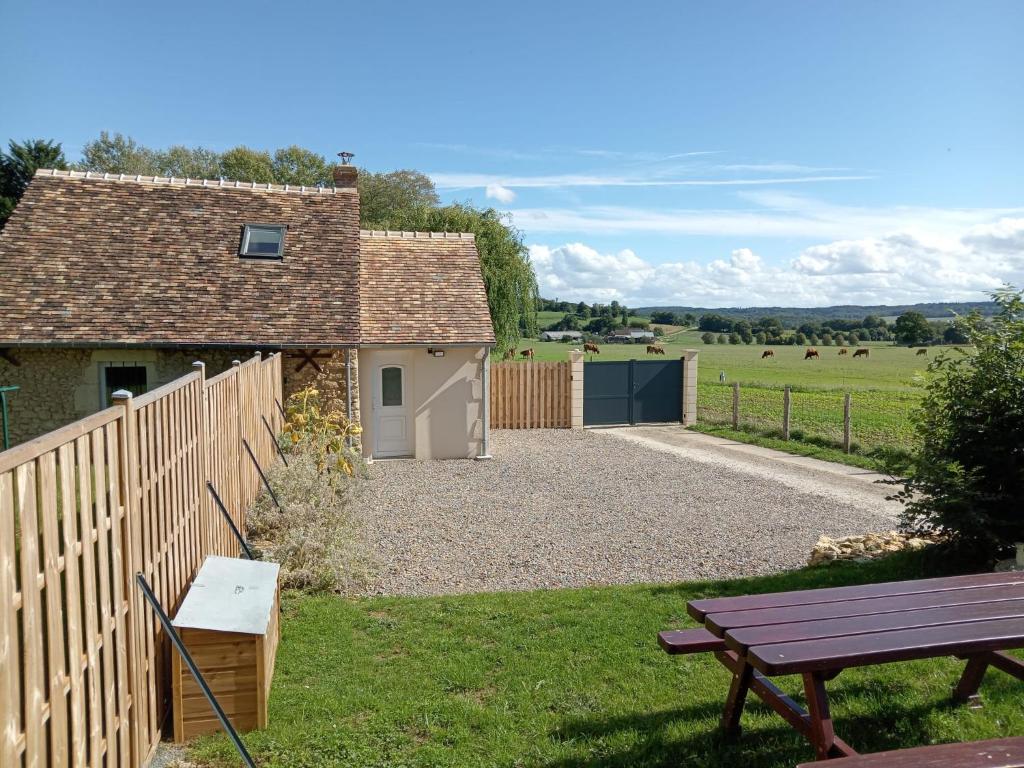 Saint-Cosme-en-VairaisにあるChez Elise et Margotの庭の柵とベンチ付きの家