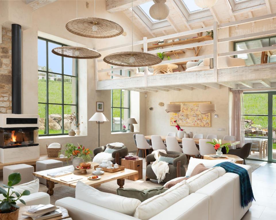 a living room with white furniture and a fireplace at Wishome-Preciosa villa recién reformada con piscina climatizada in Caviedes