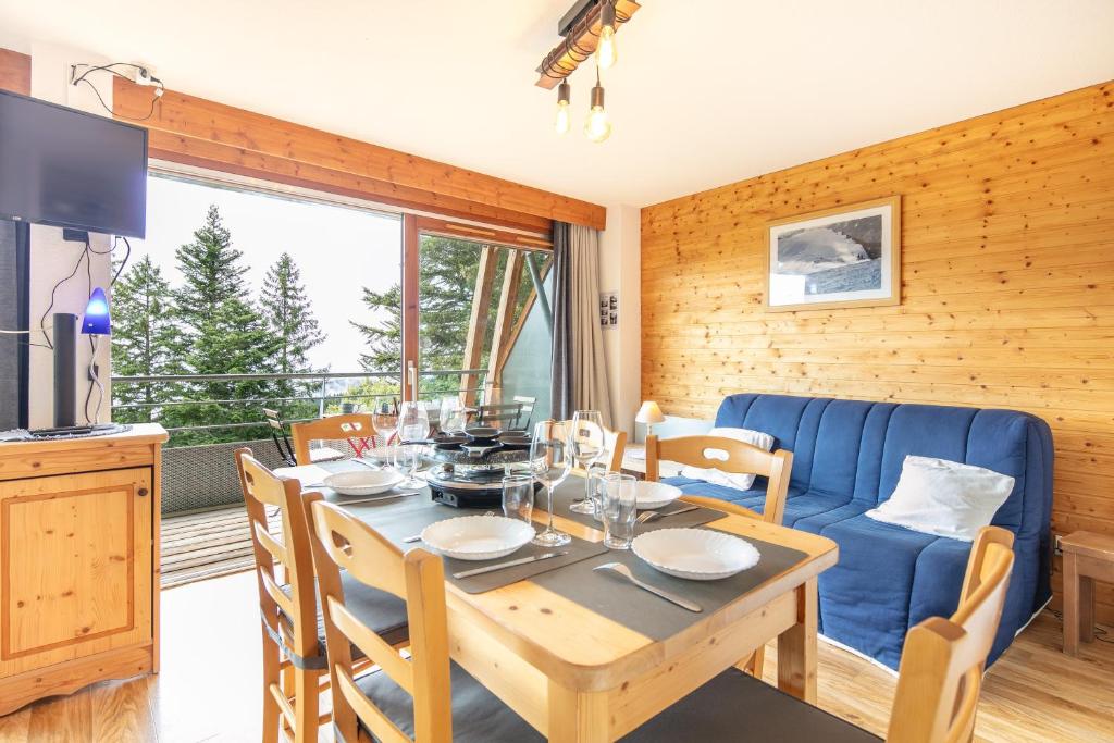 comedor con mesa y sofá azul en Epicéa E22 - Station de ski à pied, en Chamrousse