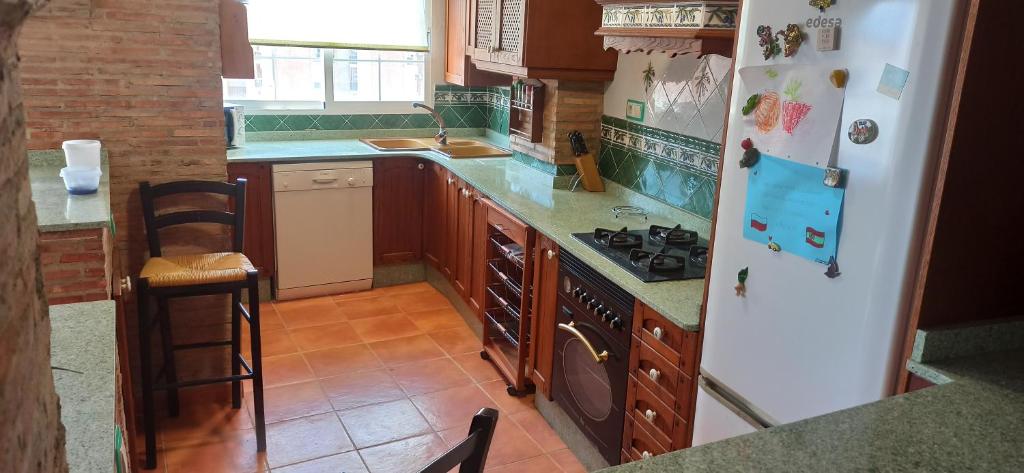 a kitchen with a white refrigerator and a stove at Casa Paola in Buñol