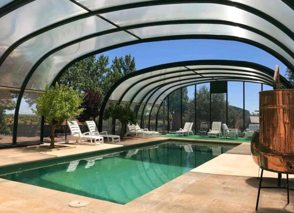 a swimming pool with an archway over the water at Finca el descanso manchego in Fuente de Pedro Naharro
