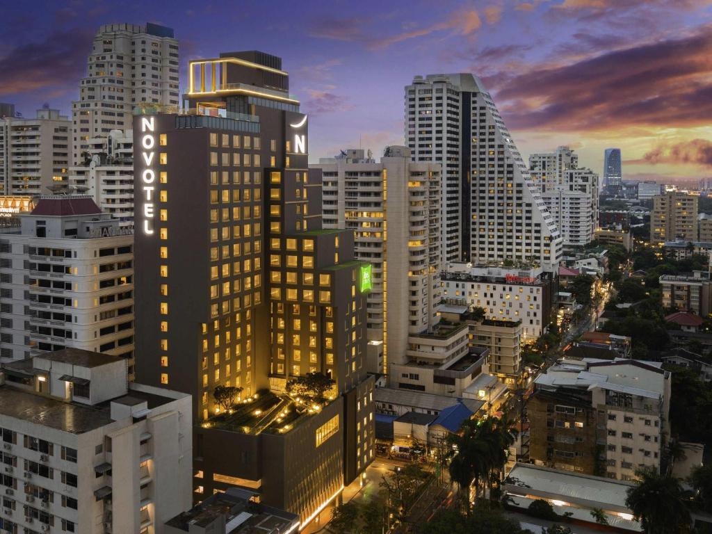a city skyline with tall buildings at night at Novotel Bangkok Sukhumvit 4 in Bangkok