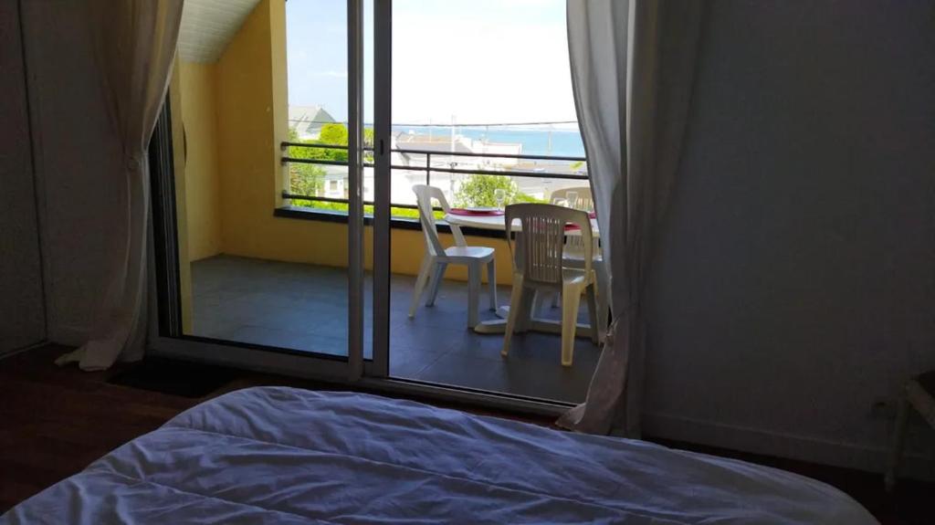 a bedroom with a balcony with a table and chairs at Maison "TY CASTERO" in Quiberon