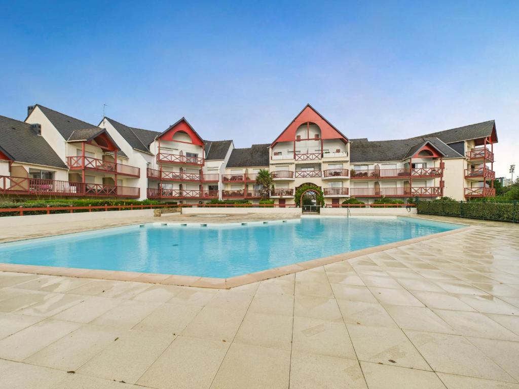 una piscina vacía frente a un gran edificio en Appartement - balcon avec vue - piscine chauffée, en Guérande