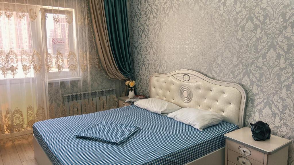 une chambre avec un lit avec un chat noir assis dessus dans l'établissement 18А Premium Plaza, à Aktau