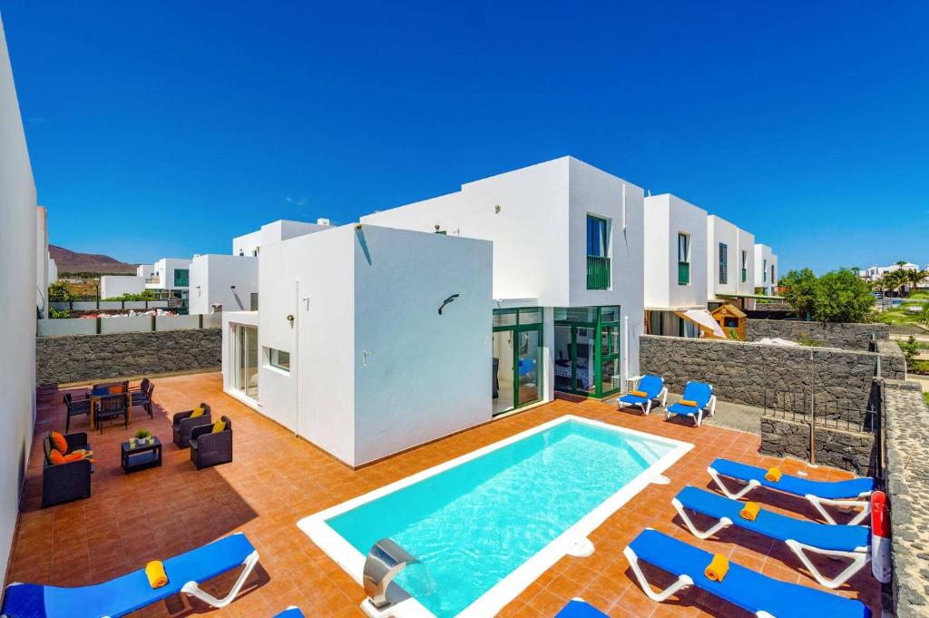 an external view of a house with a swimming pool at Villa Sunshine Lanzarote by Villa Plus in Teguise