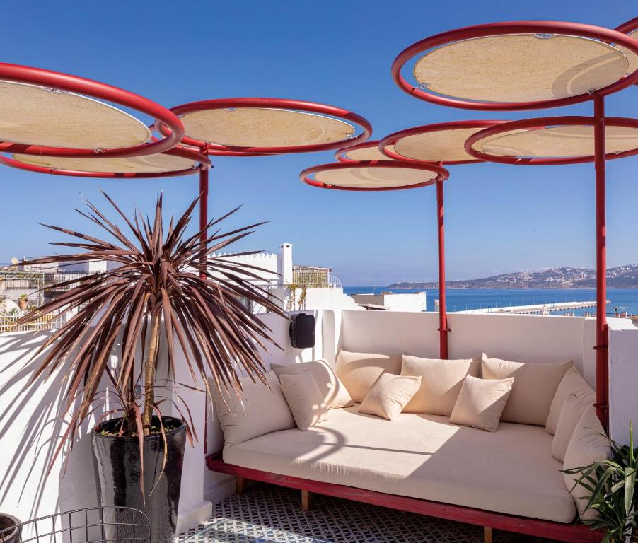 un sofá en un balcón con vistas al océano en Rooftop House in the heart of the Médina, en Tánger