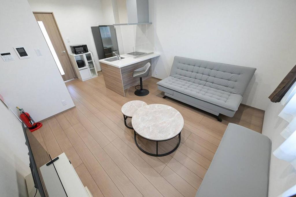 a living room with a couch and a table at LA-CHIC Stay 大津 in Ozu