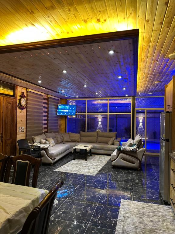 a large living room with couches and a table at شاليه وكوخ البركه Albarakah chalets in Ajloun