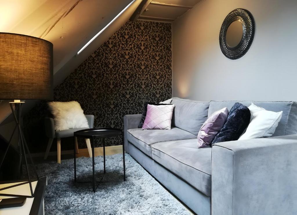 a living room with a couch and a table at Escale Glamour et Chic in Niederbronn-les-Bains