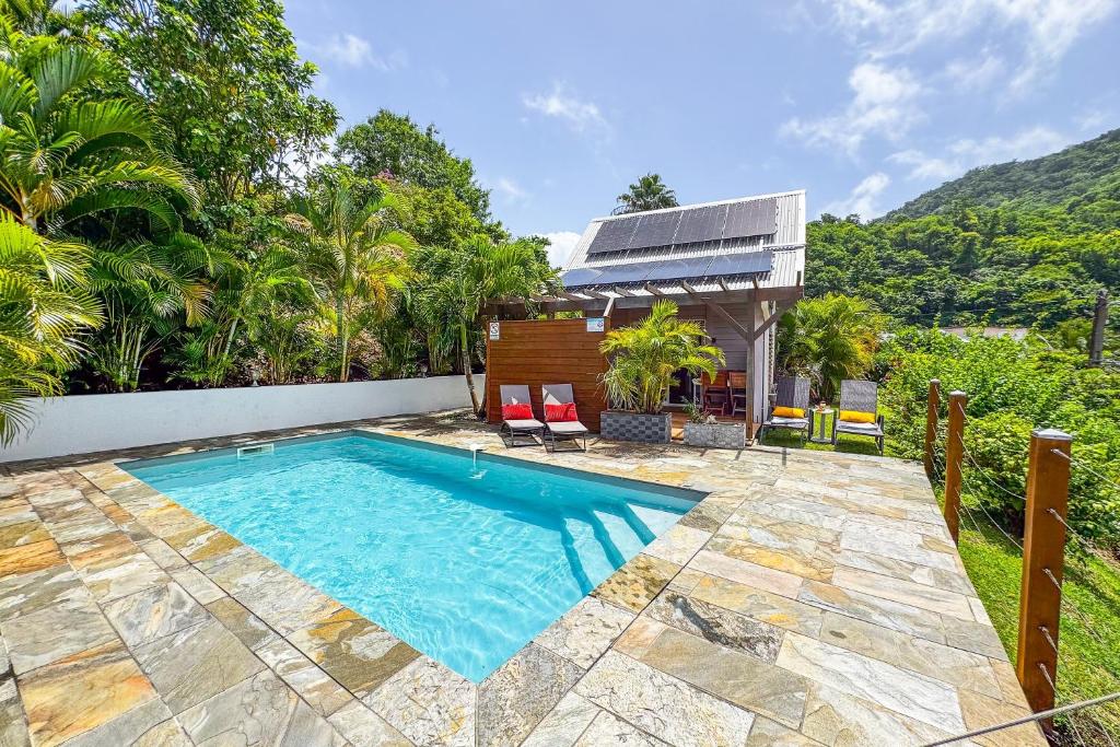 a swimming pool in the backyard of a house at Lodge 1 - Colibri - Jacuzzi Privé in Les Anses-dʼArlets