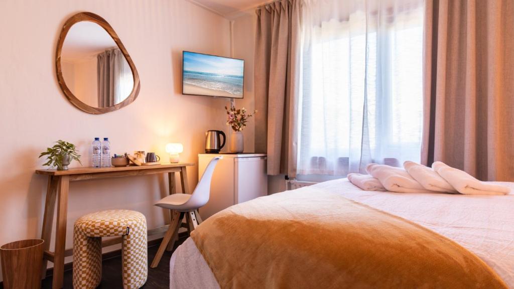 a hotel room with a bed and a mirror at BadHotel Noordwijk in Noordwijk