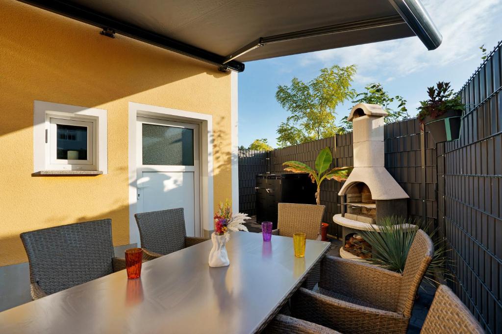 a table and chairs on a patio with a fireplace at Ferienwohnung Sophie in Lauchhammer