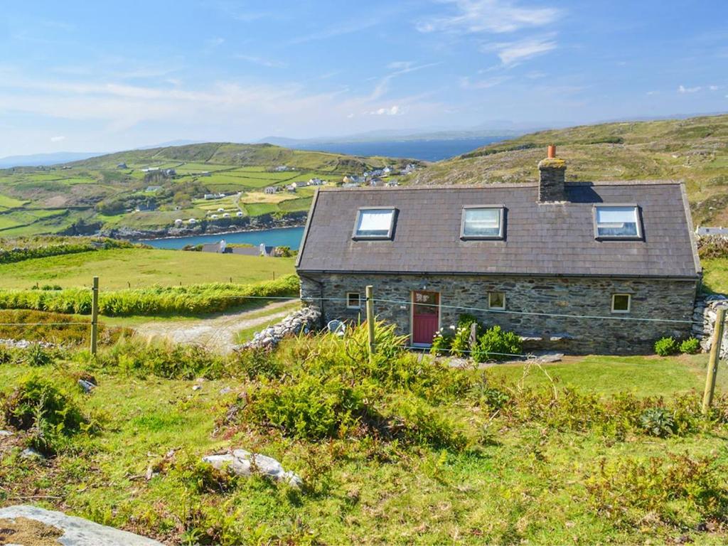 a stone house on a hill with a lake at 1 Bed in Cape Clear Island oc-ii16739 in Lissarnona