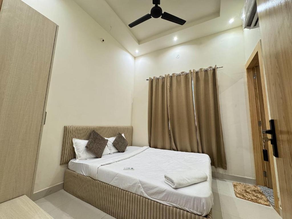 een slaapkamer met een bed met een plafondventilator bij Era Hotel and Reosrt in Kota