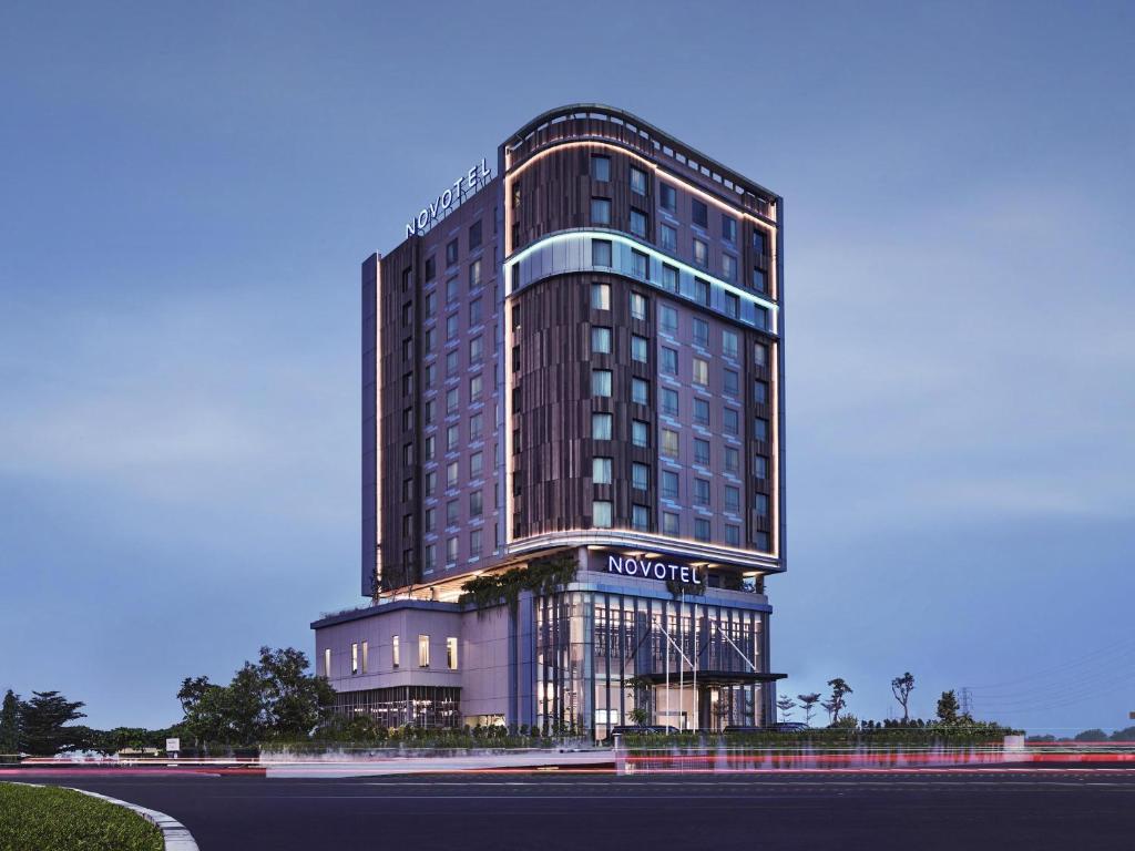 a tall building with a hotel sign on it at Novotel Karawang in Karawang