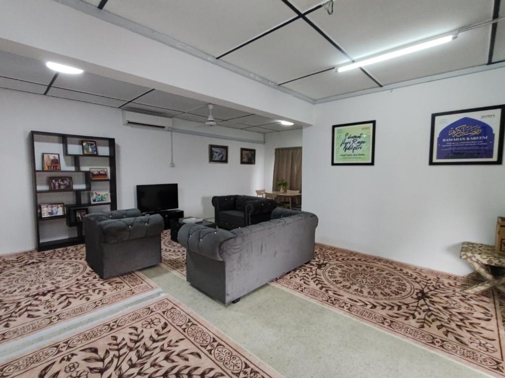 Una sala de estar con dos sillas y un sofá. en DRH Villa, en Ipoh