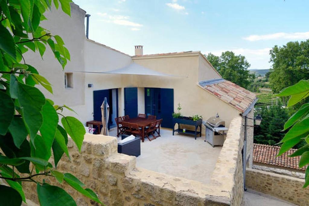 une terrasse d'une maison avec une table et des chaises dans l'établissement Les Galets, Enjoy Luberon Lifestyle, à Cucuron