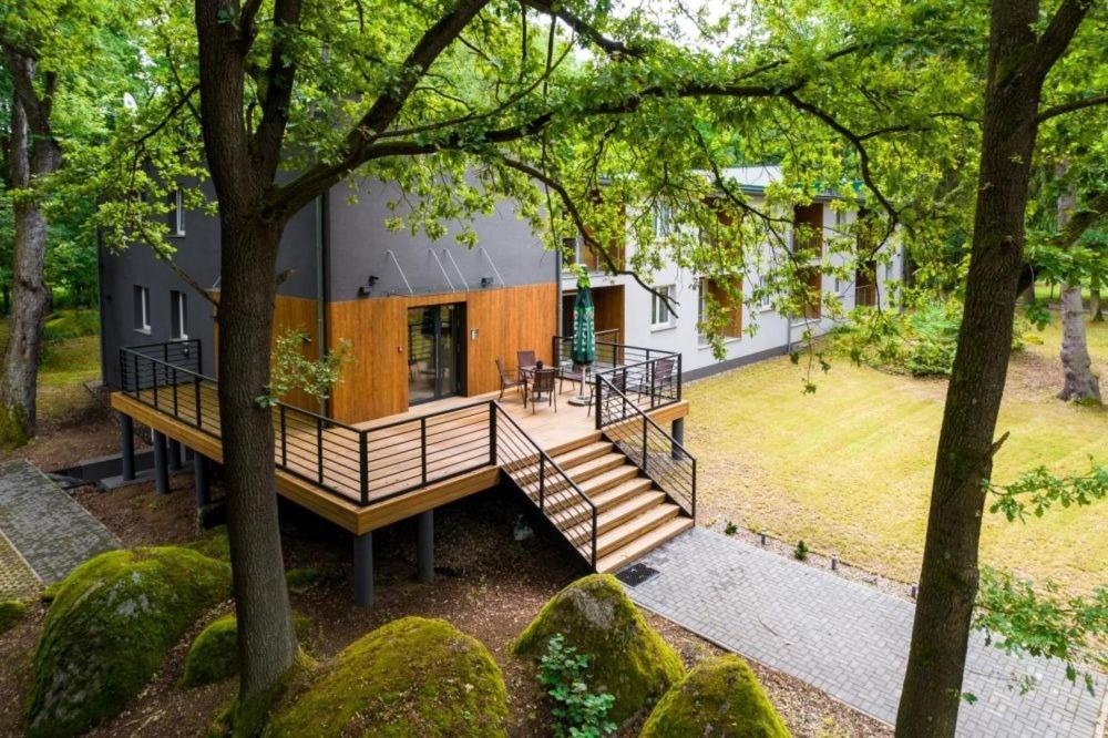 a house with a large deck in the middle of a yard at Apartamenty Dąbrówka Beauty - w parku leśnym , sauna in Jelenia Góra