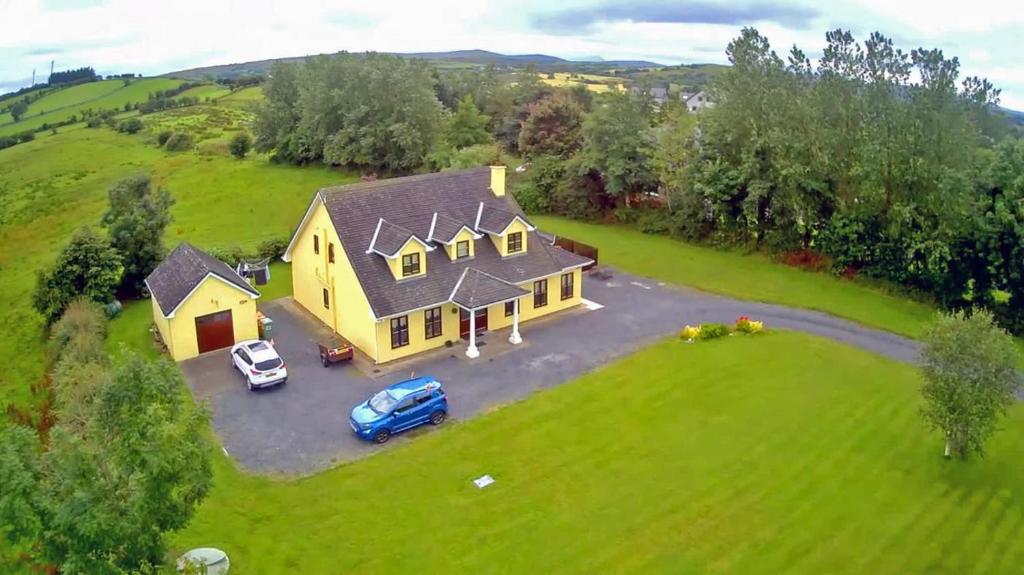 an aerial view of a yellow house on a green field at 5 Bed in Westport oc-ii06251 in Aghagower