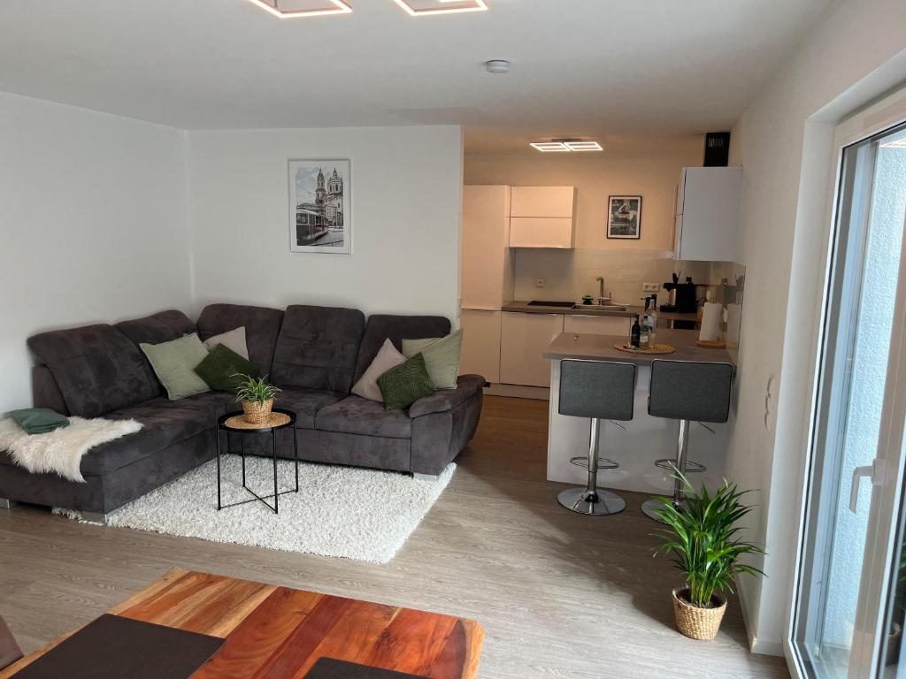 a living room with a couch and a kitchen at Helles & modernes Apartment mit privater Terrasse in Schwäbisch Hall