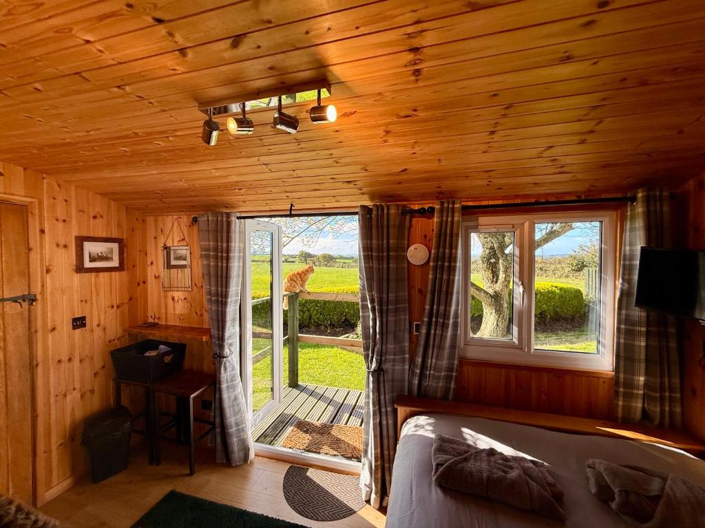 a bedroom with a bed and a window in a cabin at Stags Hide in Minwear