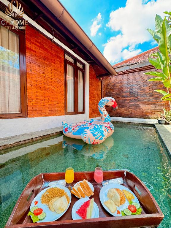 a pool of water with a tray of food in it at chrome hotel & resort solo in Tjolomadu