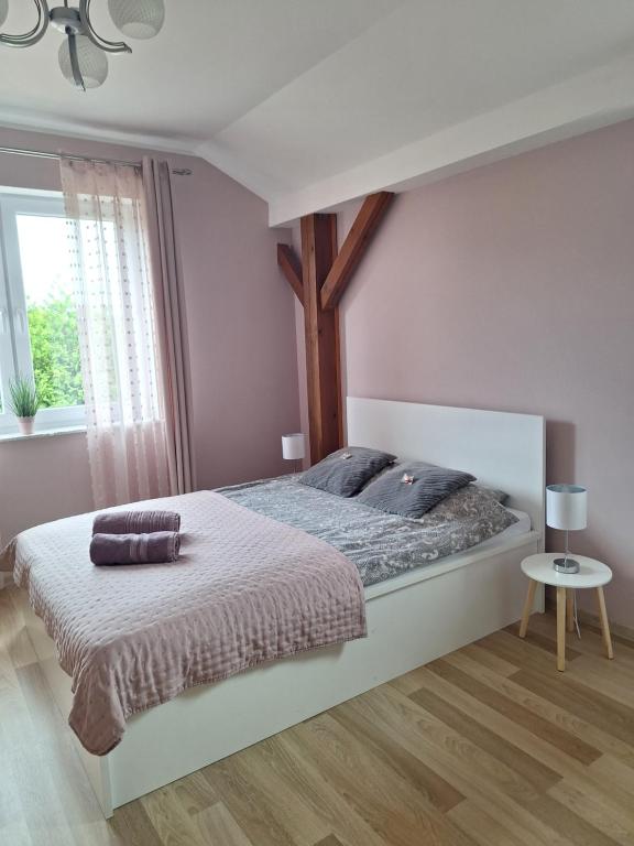 una camera da letto con un grande letto con una croce sopra di Apartament Platynowy - Malbork a Malbork
