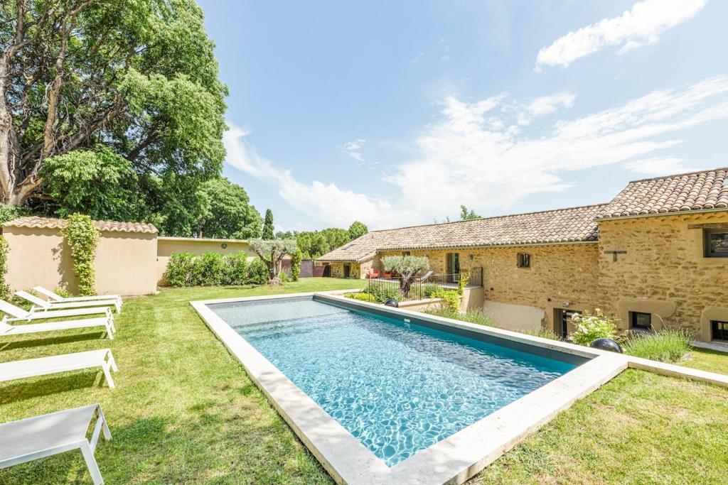 a swimming pool in the yard of a house at La Bastide du Père Mathieu Jacuzzi couvert et Piscine in Suze-la-Rousse