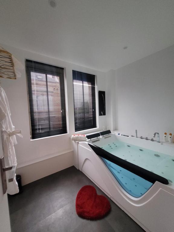 un bagno con una vasca con un cuore rosso dentro di Loveroom Instants Secret Amiens ad Amiens