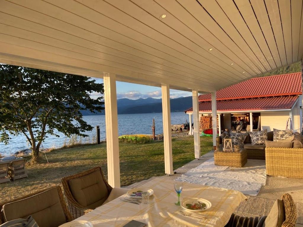 een patio met een tafel en stoelen en het water bij House with oceanview in Stryn