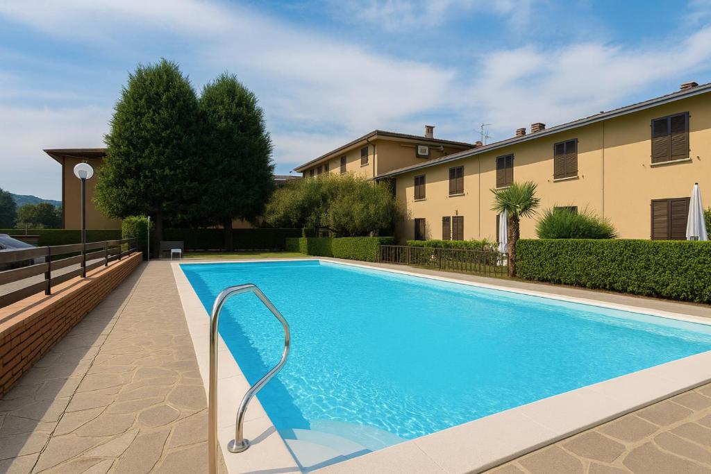 a swimming pool in front of a building at PARATICO - Lakefront apartment with private pool and free parking in Paratico
