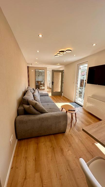 a large couch in a living room with wooden floors at Ferienwohnung Anja in Münnerstadt