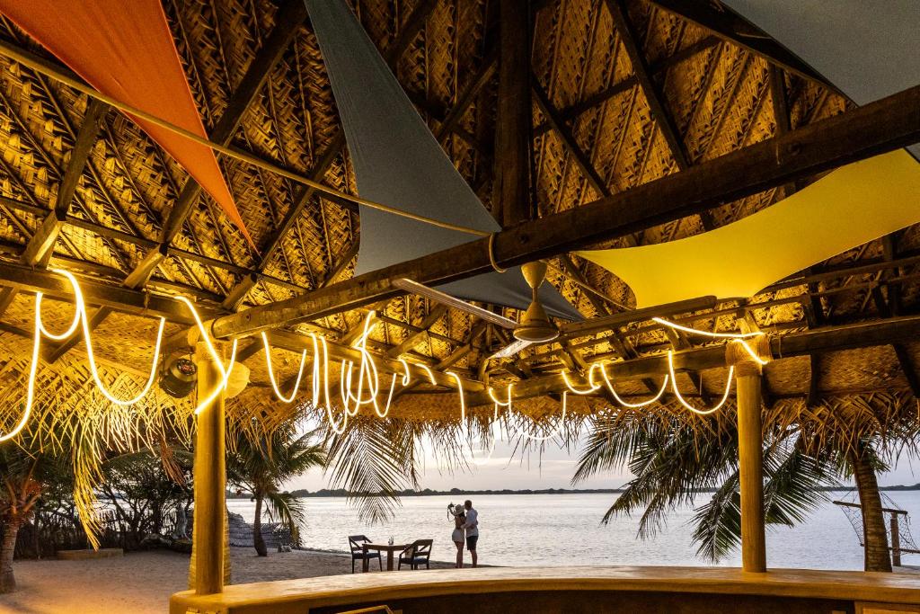 a person standing under an umbrella on the beach at Barramundi in Kalpitiya