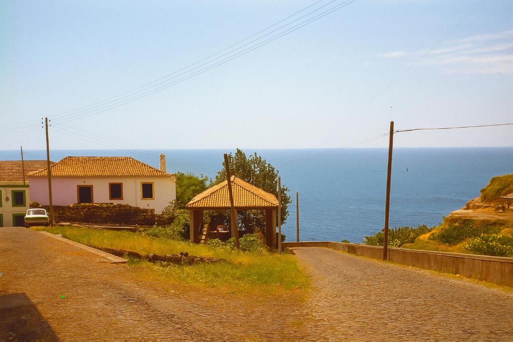 a dirt road with a house and a gazebo at SeaSalt Whisper - Guest House in Calheta