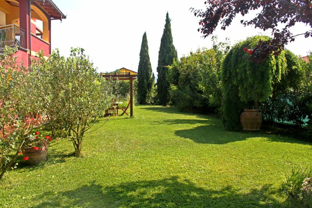 einen grünen Garten mit einem Pavillon und Bäumen in der Unterkunft Di Luna e Di Sole in Sarzana