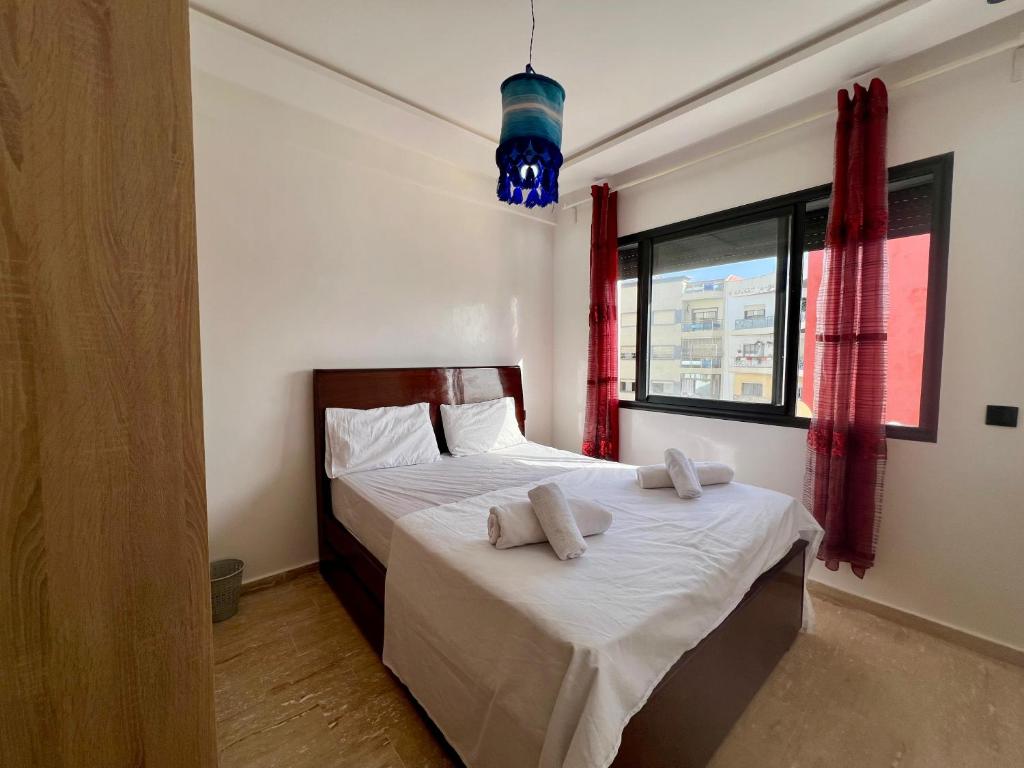 a bedroom with a bed with two pillows on it at Casablanca Yamanda Appartement - Ain Sebaa in Casablanca