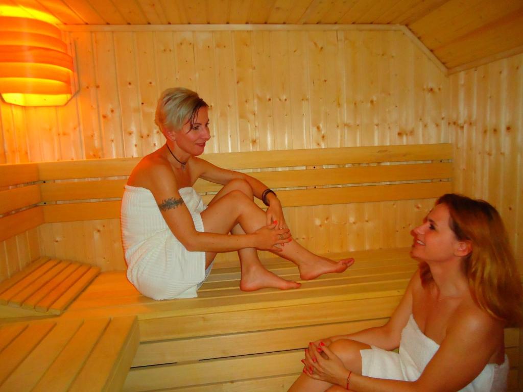 two women are sitting in a sauna at Apartament Szarotka in Szczawnica