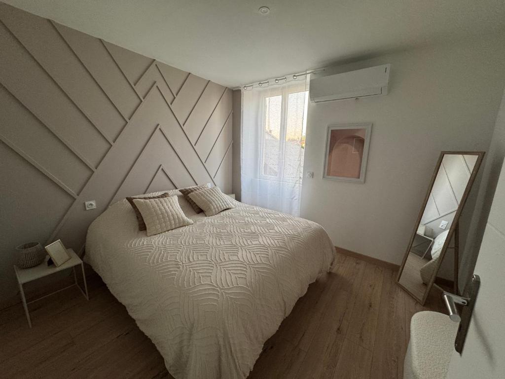 a bedroom with a large bed and a window at Confort & Charme in Grignols